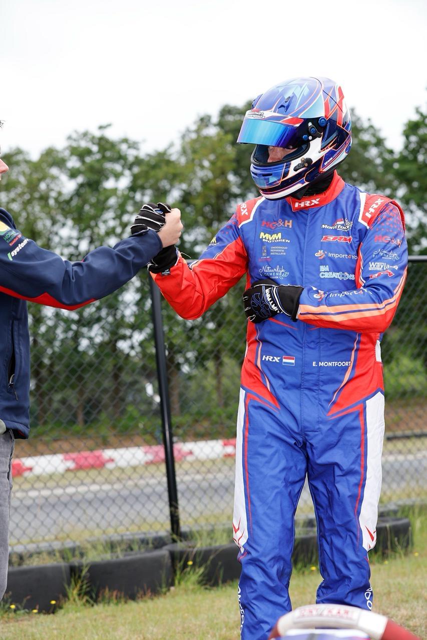 Erwin Montfoort celebrating with team after race at United Karting Series Berghem — Wayland Industries Holding sponsorship visible on suit